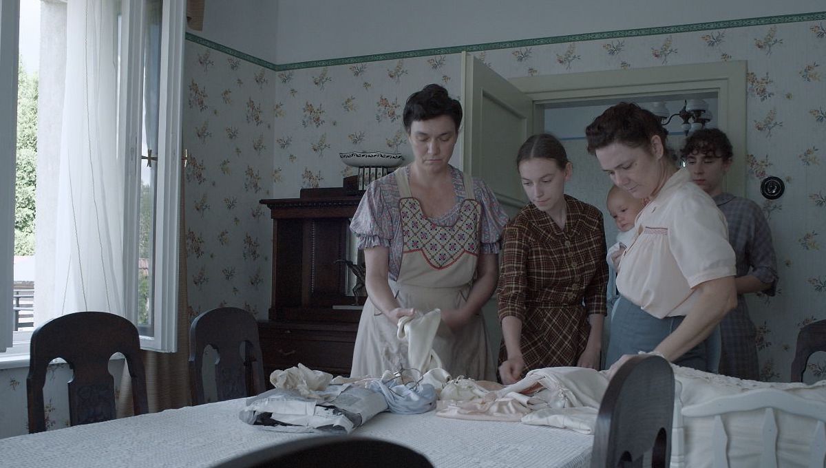 A group of women polish silver at a dining table in The Zone of Interest.