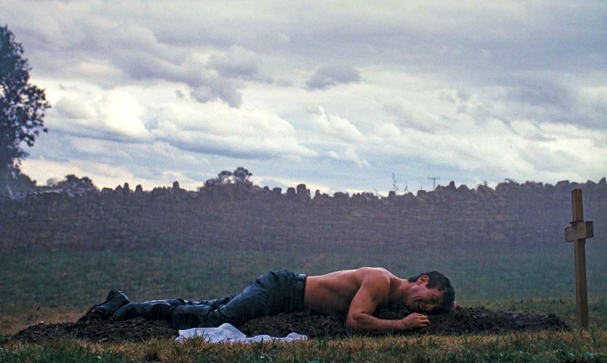 Oliver (Barry Keoghan) cries over a grave in 'Saltburn.'