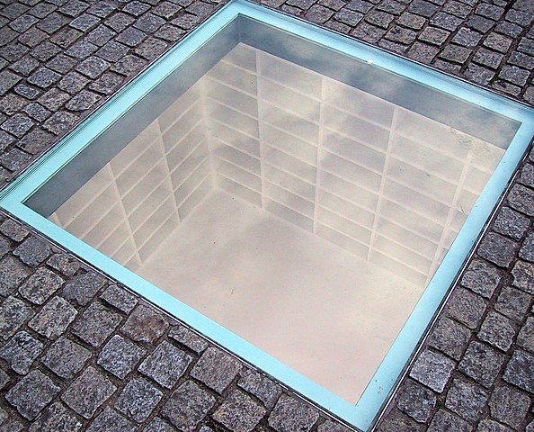 Wiki description: Monument to the May 10, 1933 Book burning: Designed by Micha Ullmann, empty bookshelves, enough to hold all 20,000 burned books, visible below the pavement of Bebelplatz in Berlin, Germany. 