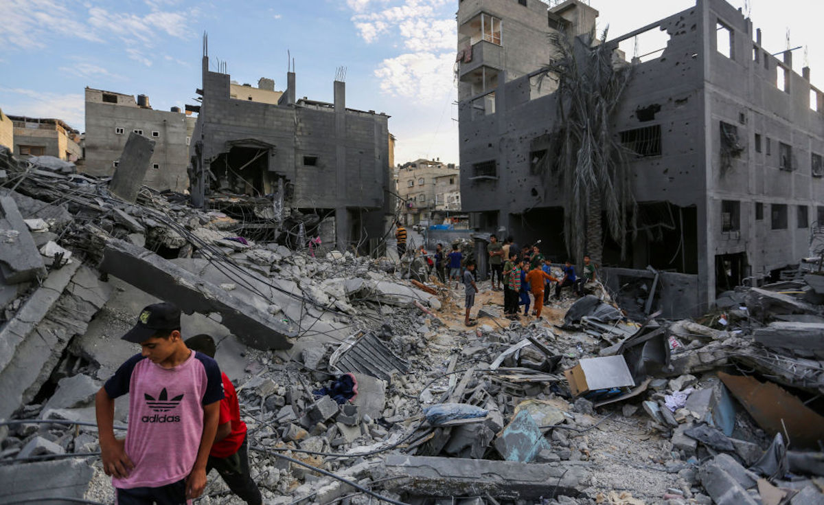 Gazans stand in the rubble of buildings in Khan Younis.