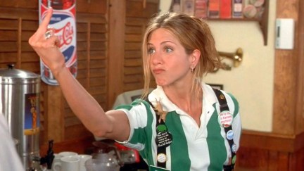 A white woman (Jennifer Aniston) flips the bird in a scene from Office Space.