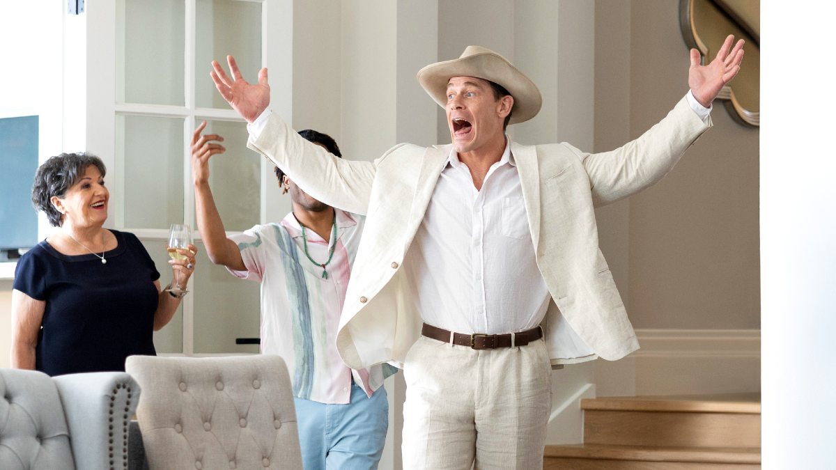 John Cena wears a white suit and jaunty hat in 'Ricky Stanicky.'