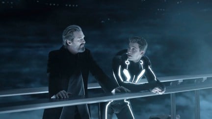 Jeff Bridges and Garrett Hedlund standing on a bridge together in Tron: Legacy