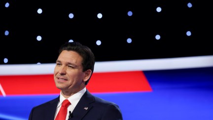 Ron DeSantis smiles awkwardly on the debate stage.