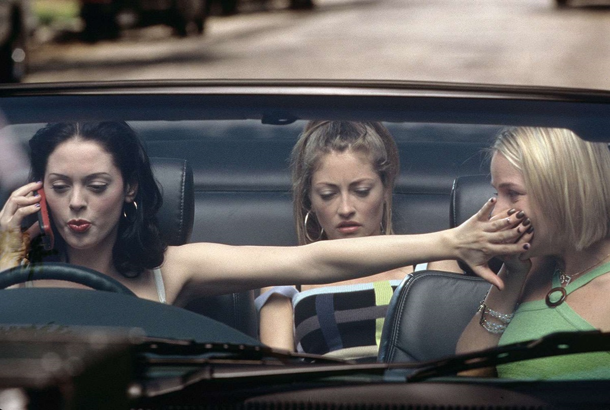 Rose McGowen covers Julie Benz's mouth while driving car. Rebecca Gayhart sits in backseat