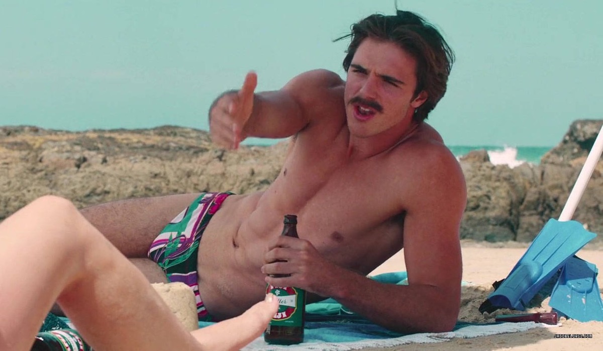 Jacob Elordi in a Speedo drinking a beer on the beach