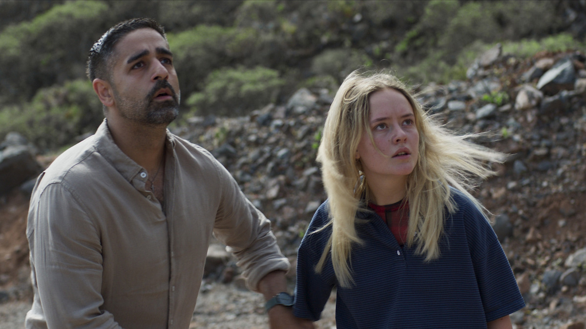 a man and a woman look at a disaster in fear