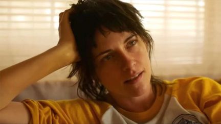 Kristen Stewart rests her head on her palm as Lou in A24's 'Love Lies Bleeding'