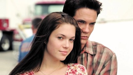 A young couple stand together in the street in 