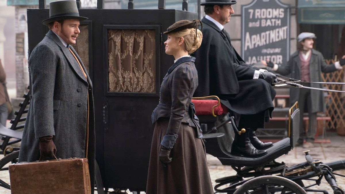 Felix Scott and Kate Phillips stand in front of a carriage in 'Miss Scarlet' season 5