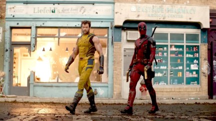 deadpool and wolverine walking in front of an explosion and store named 