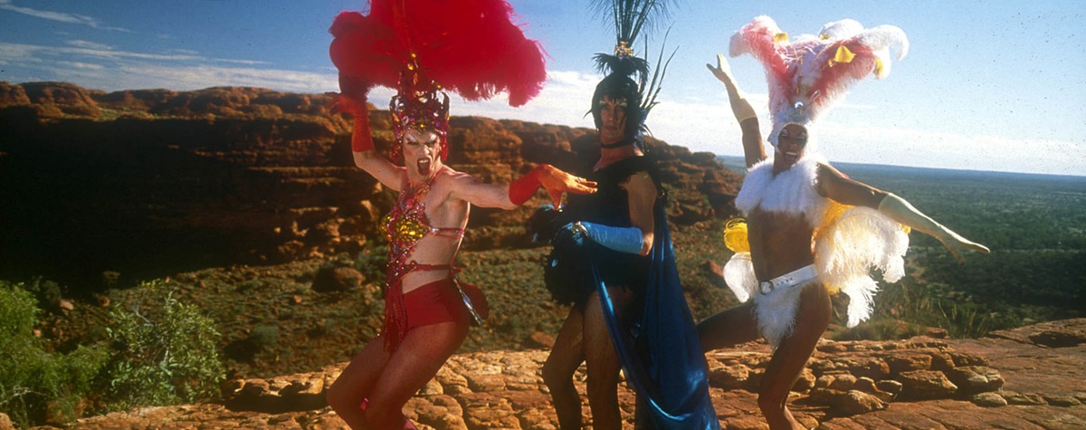 Three glamorous queens in show girl costumes in the desert