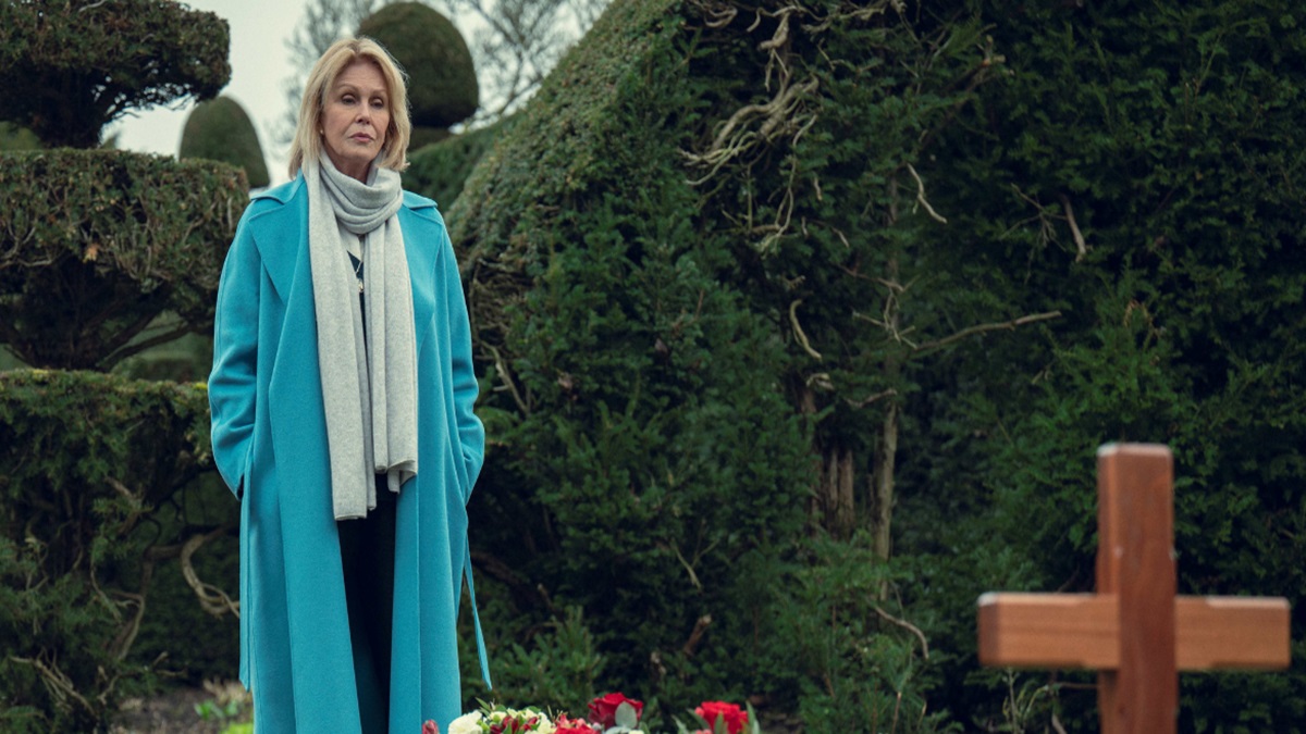 A woman (Joanna Lumley) stands by a grave