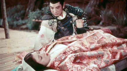 A samurai peers down at a sleeping woman in 