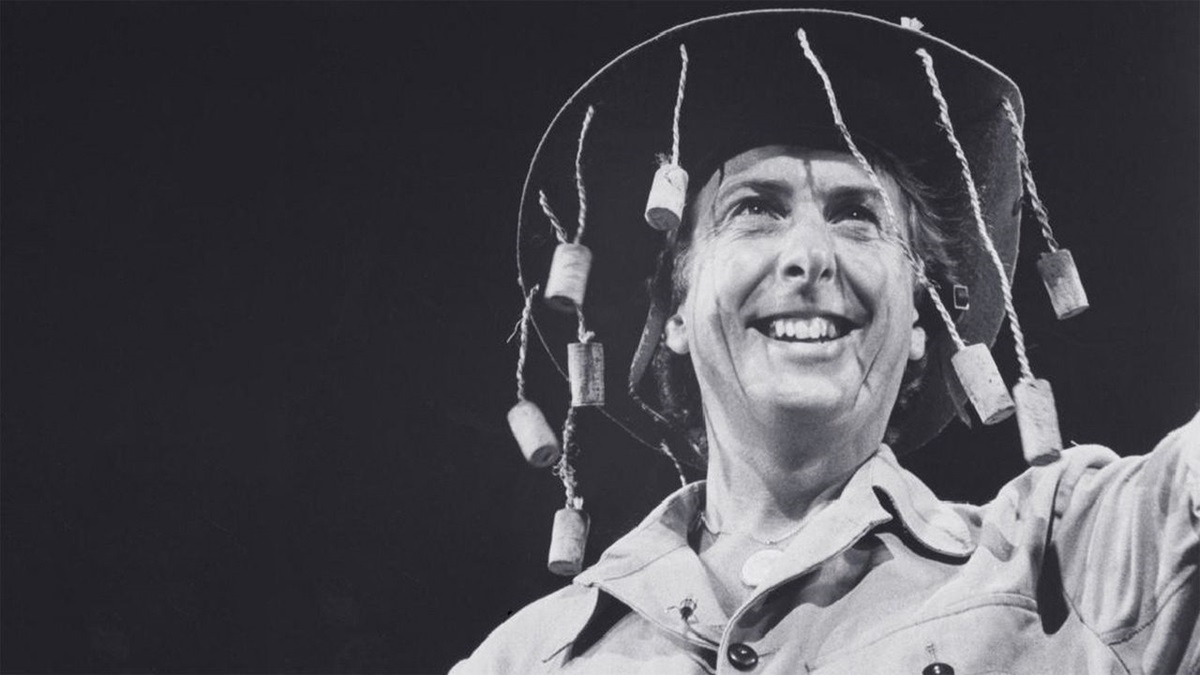 Eric Idle wearing a hat with corks dangling from the rim