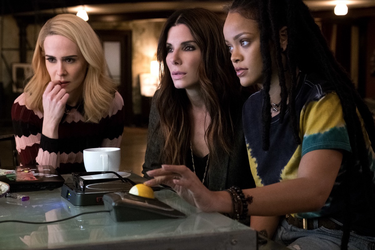 Three women look concerned sitting at a bar in "Ocean's 8"