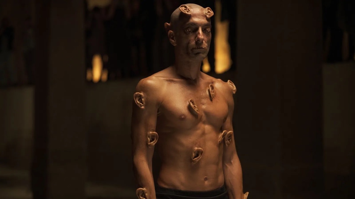 A naked man stands with ears growing out of his body in "Crimes of the Future" 