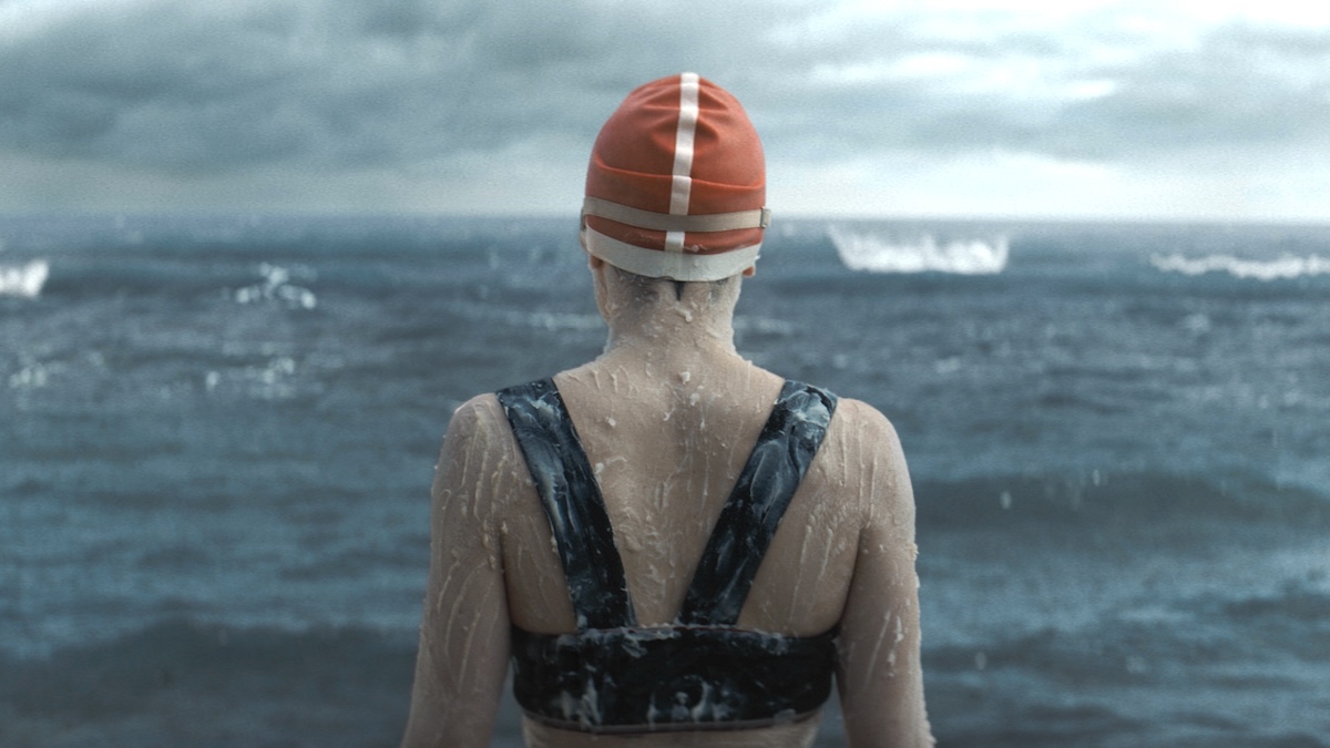 Daisy Ridley facing the water looking at the sea