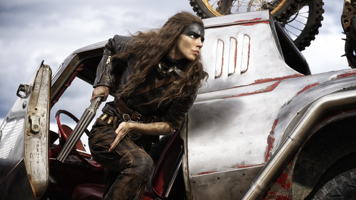 Furiosa next to a car with a gun.