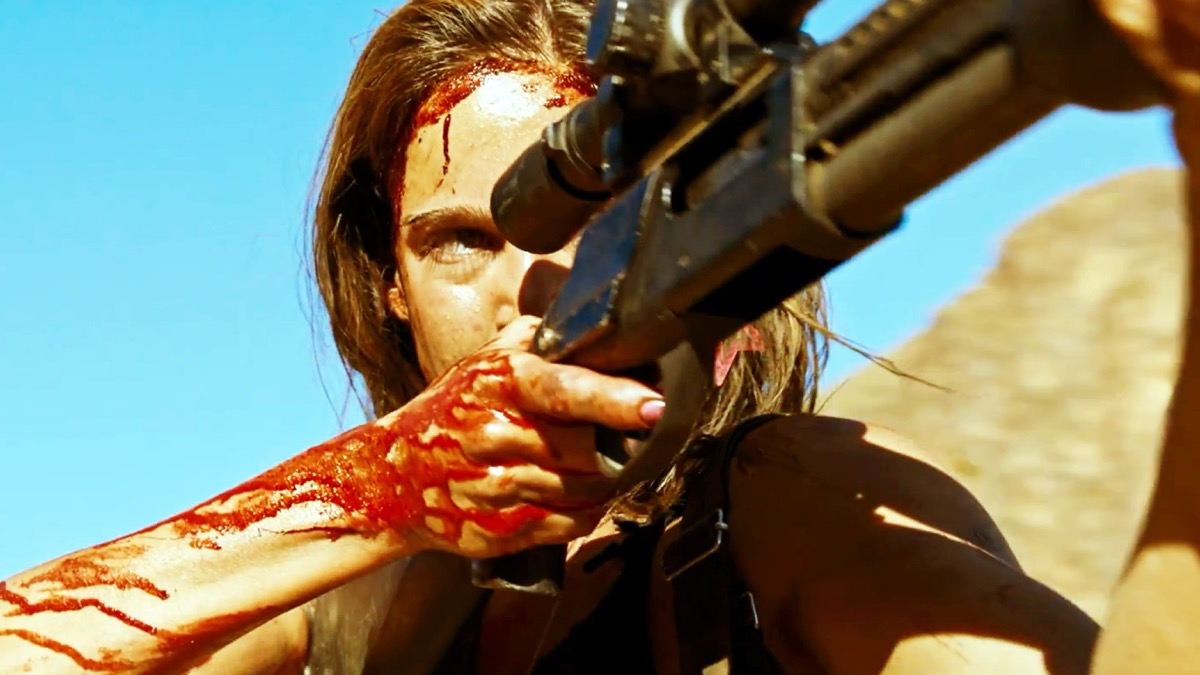 A bloody woman in the desert aims a hunting rifle in "Revenge" 