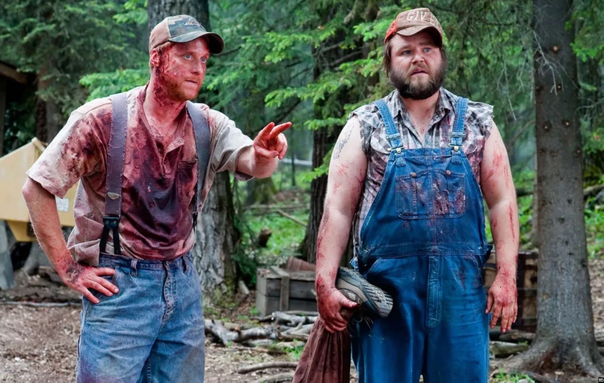 Two blood spattered country bumpkins stand in the woods in "Tucker and Dale vs. Evil"