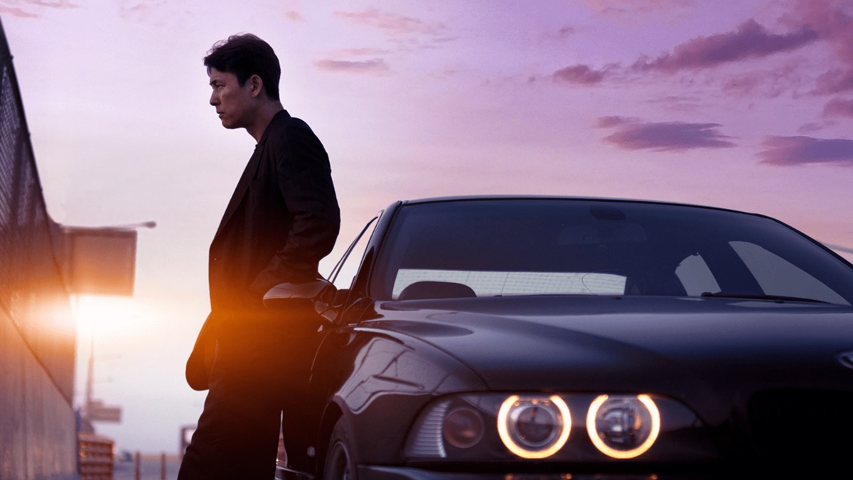 A man leans against a car