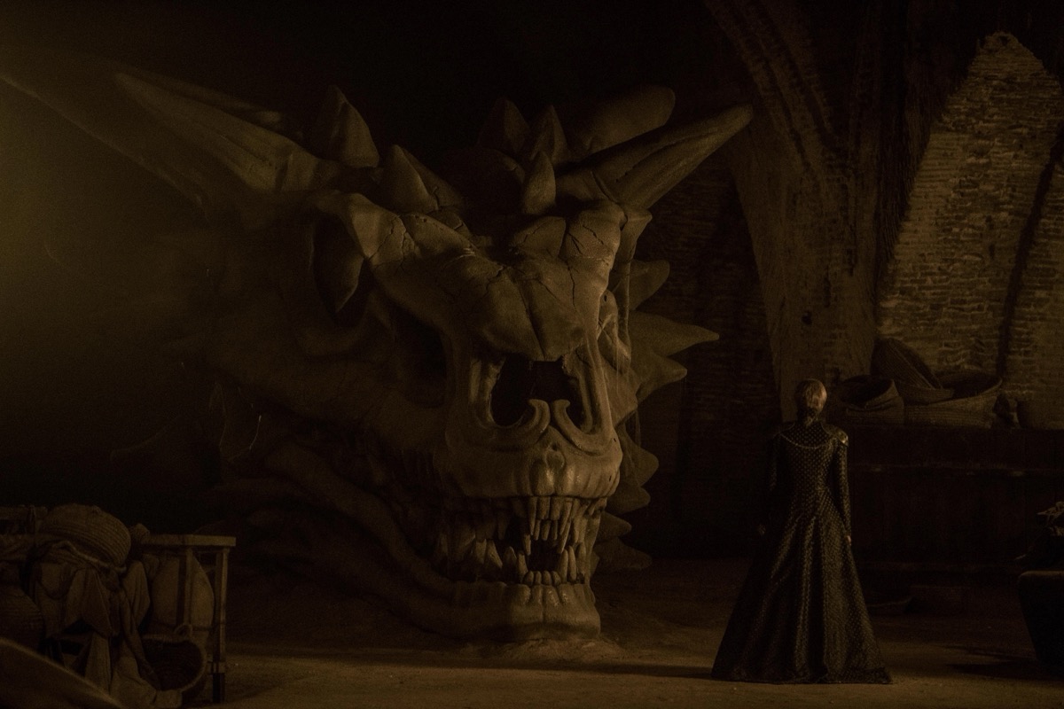 A woman looks at the skull of a massive dragon in "Game of Thrones" 