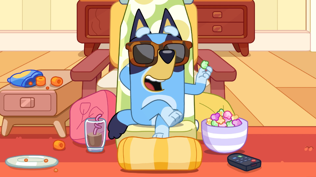 Bluey wearing sunglasses and watching TV with snacks