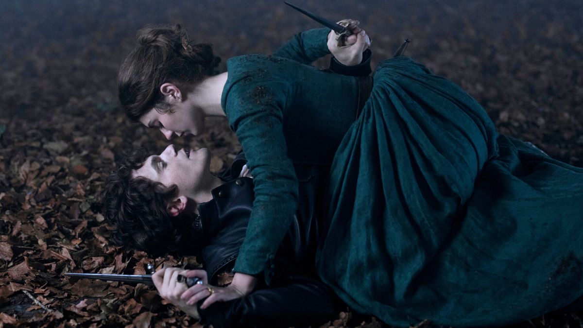 Emily Bader and Edward Bluemel fighting in the grass in a scene from My Lady Jane