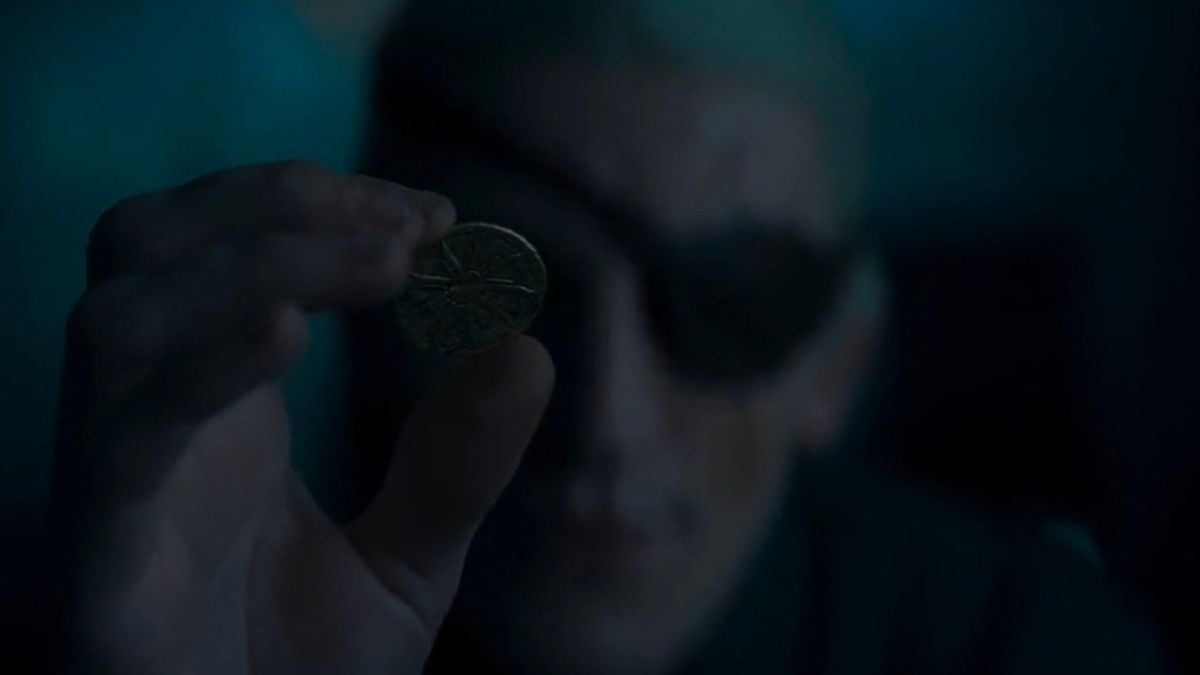 Aemond Targaryen, joué par Ewan Mitchell, inspecte une pièce de monnaie dans le deuxième épisode de la deuxième saison de House of the Dragon