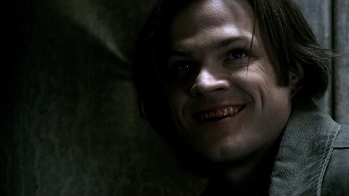 Jared Padalecki as Sam Winchester smiles with blood on his mouth in scene from Supernatural