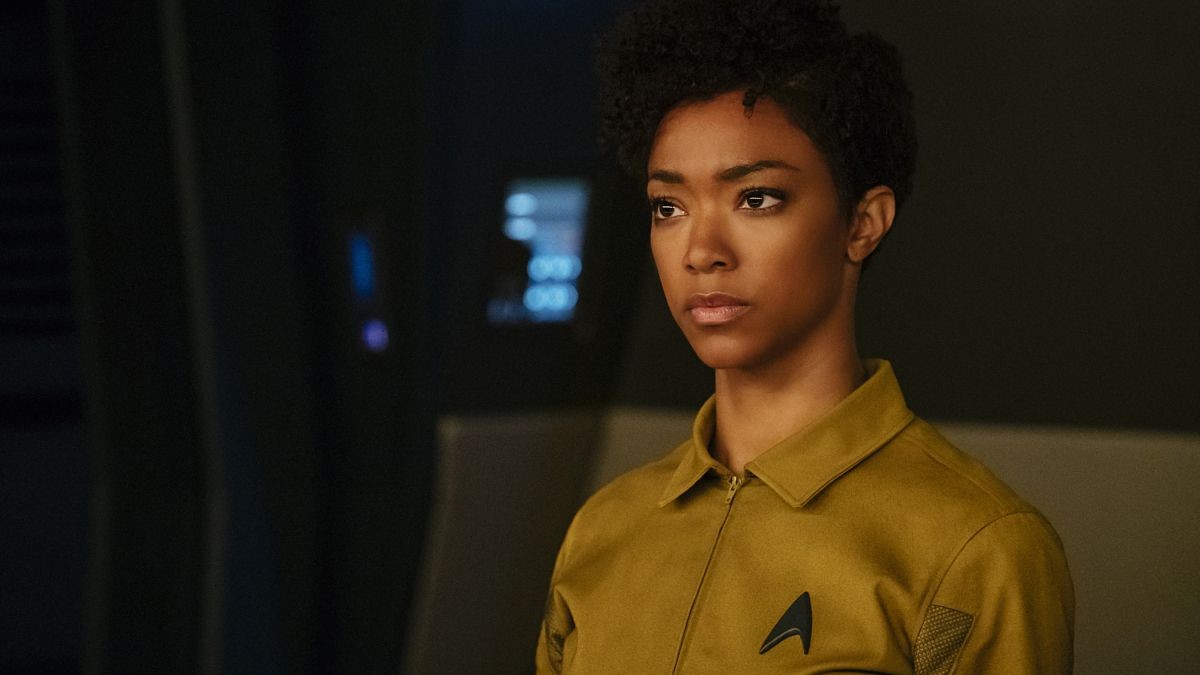 Sonequa Martin-Green as Michael Burnham on 'Star Trek: Discovery.' She is a Black woman with short, curly black hair wearing a mustard-colored Starfleet prison uniform.