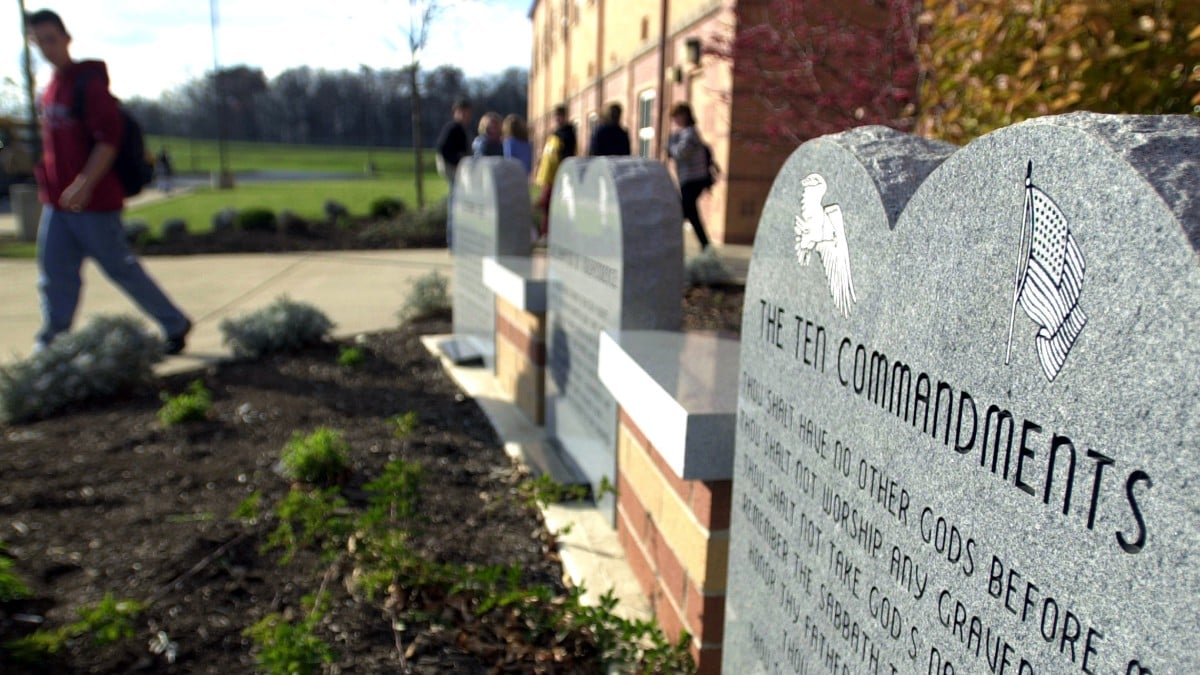 A student walks past the Ten Commandments displayed on school grounds