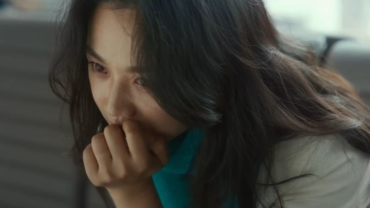 Close-up on a young Korean woman with tears in her eyes.