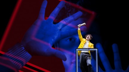 ali louis bourgazi as tommy on stage with his hand in the air