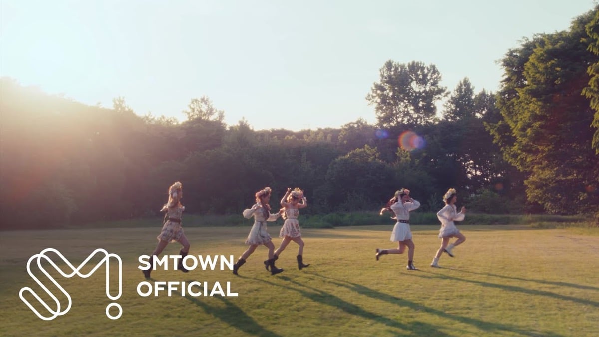 A still of Red Velvet running across a field in the Cosmic music video.