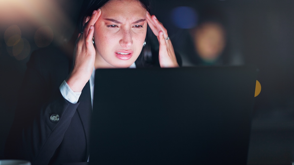Headache, night and a business woman in the office with burnout or neck pain during overtime work. Stress, deadline and pressure with a young employee in the professional workplace on a dark evening