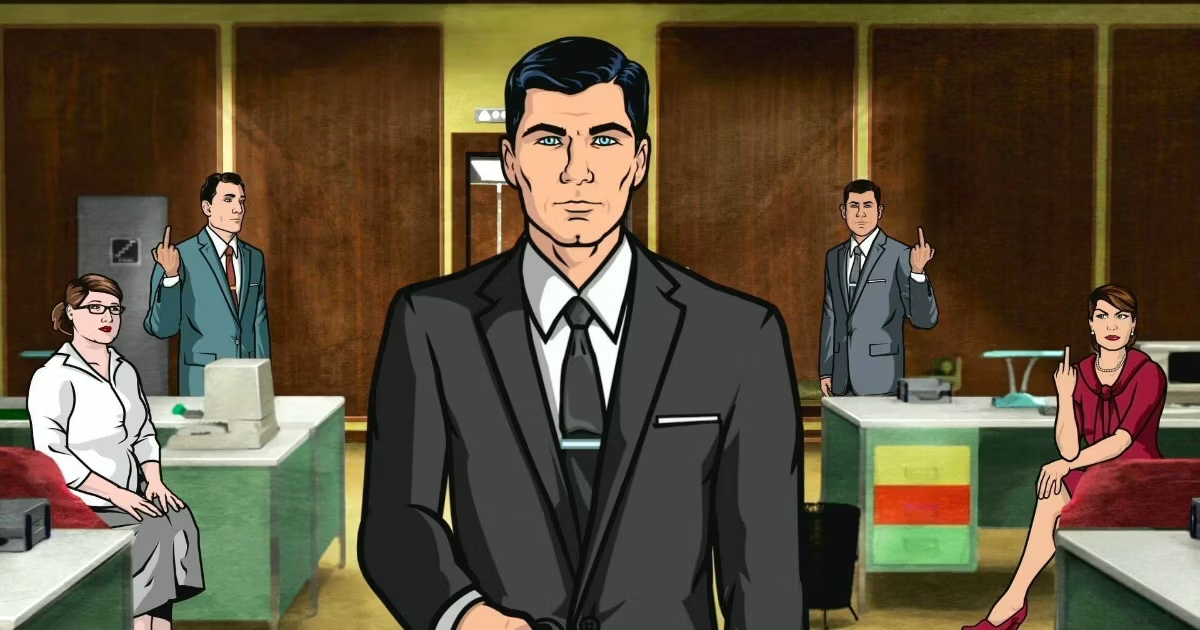 A man in a suit stands in an office with coworkers in "Archer"