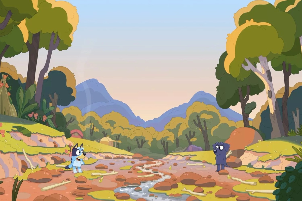 An animated dog child hangs out with another on the other side of a river  in "Bluey" 