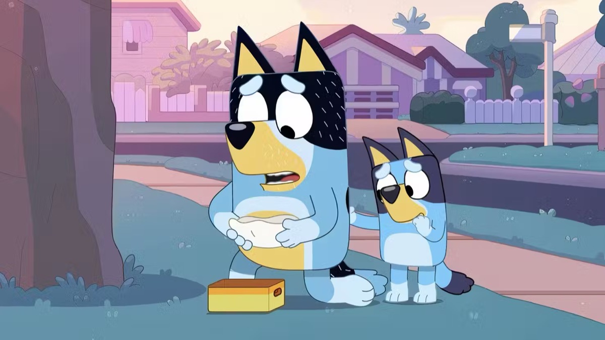 An animated dog and his daughter pick up an injured bird in "Bluey"