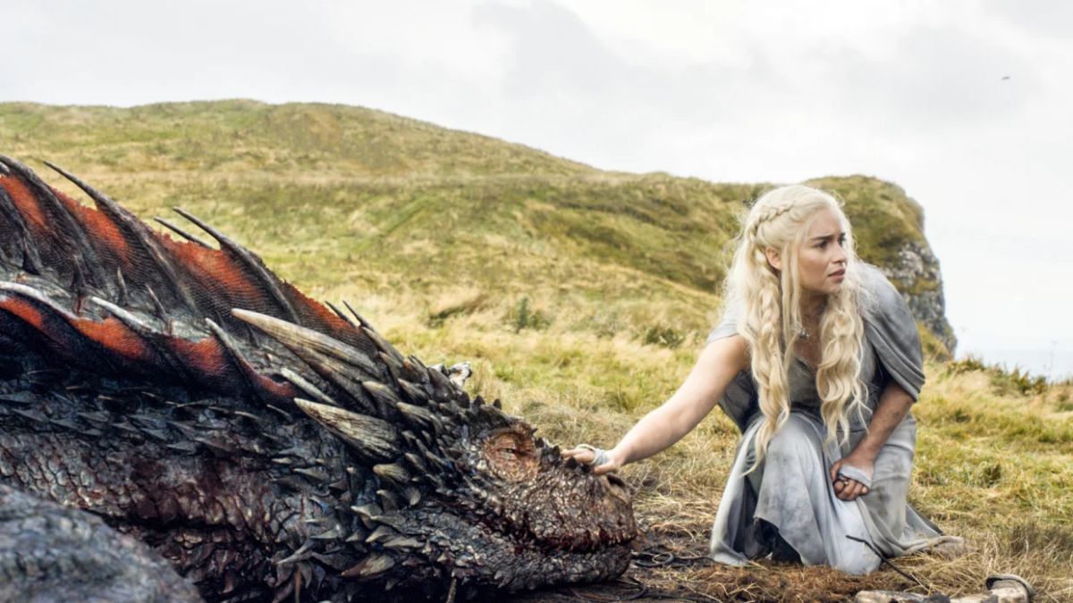 Emilia Clarke as Daenerys Targaryen pets Drogon the dragon in Game of Thrones