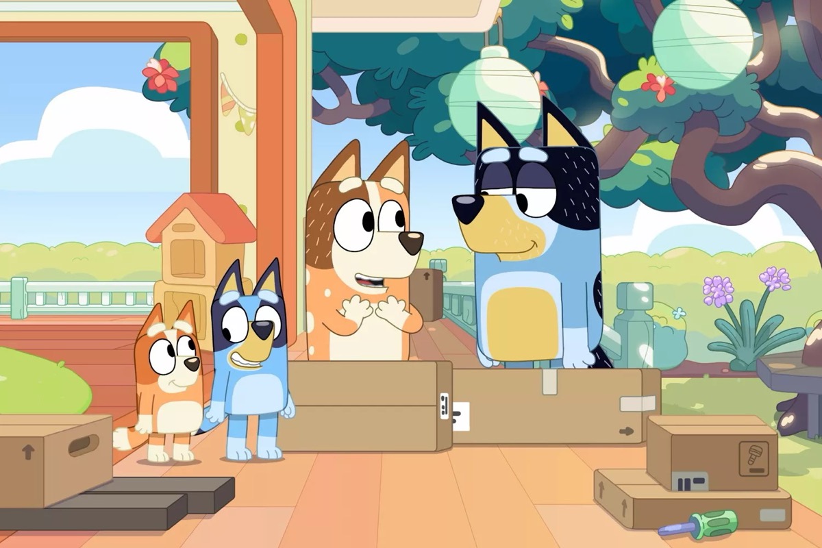 An animated dog family stand in a room filled with packing materials in "Bluey" 