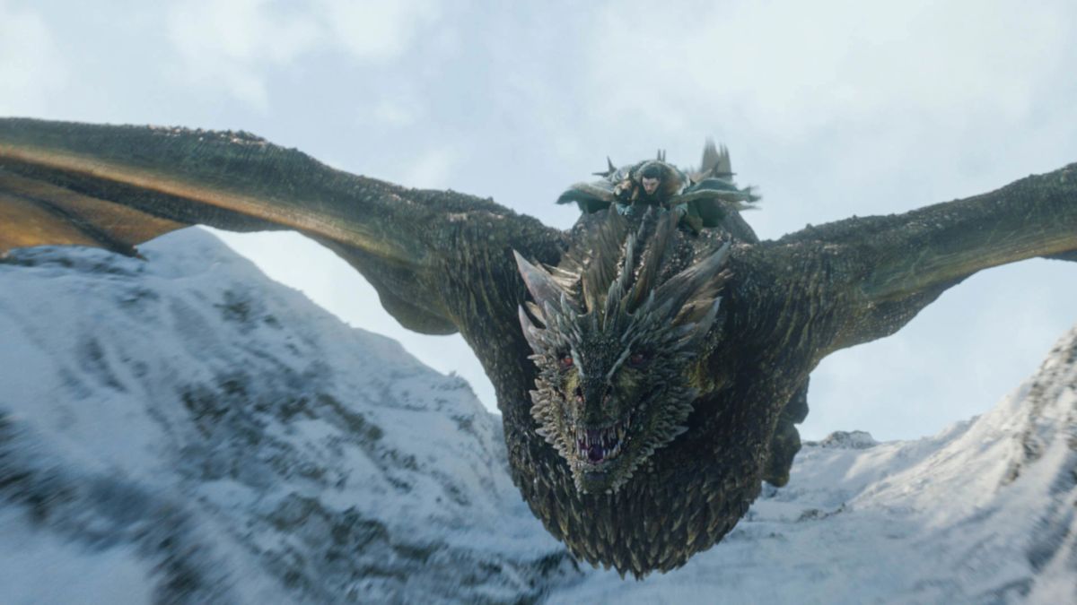 Kit Harington as Jon Snow rides the dragon Rhaegal amidst snow-covered mountains in Game of Thrones