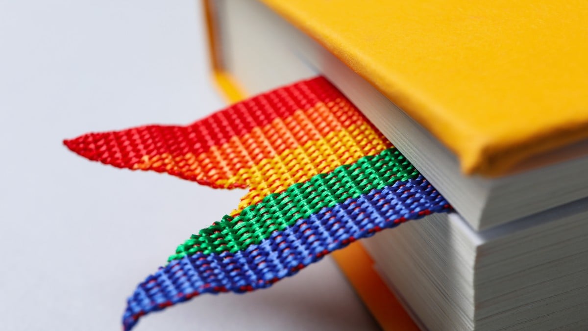 A pride bookmark inside of a yellow book