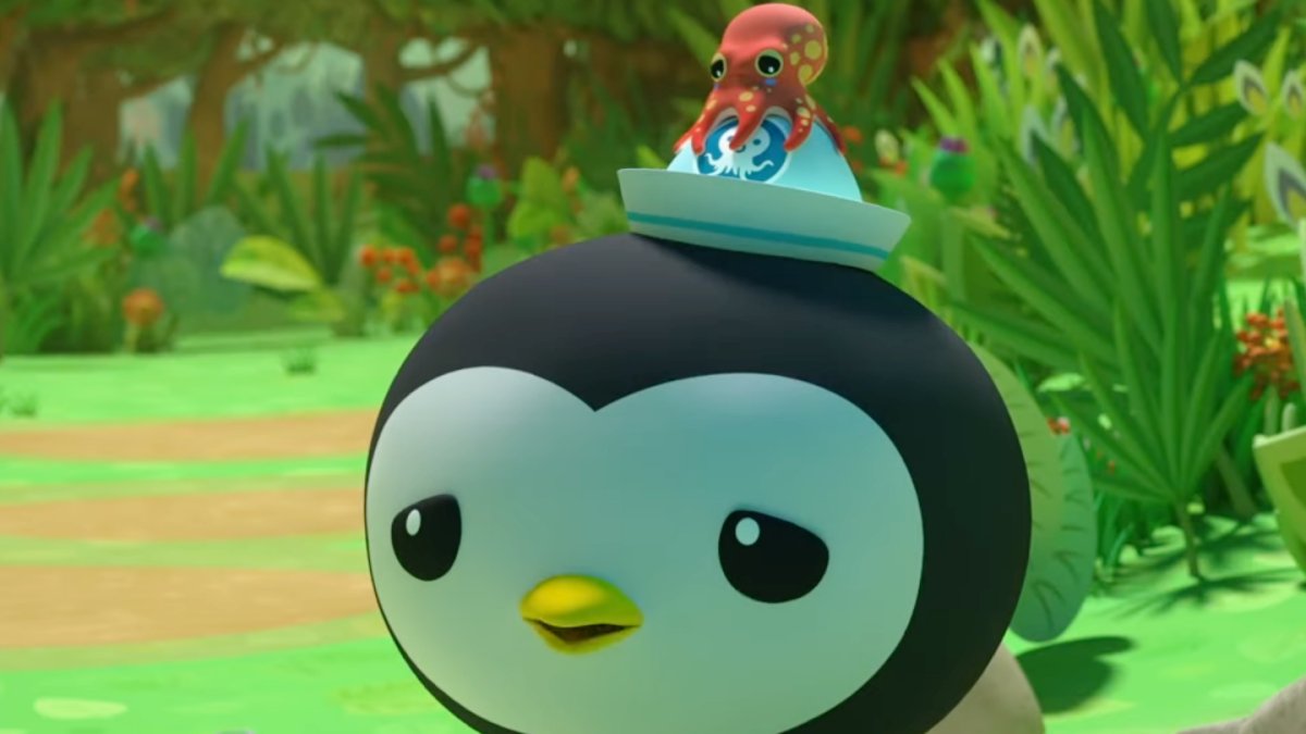 A penguin with a little red octopus on his hat