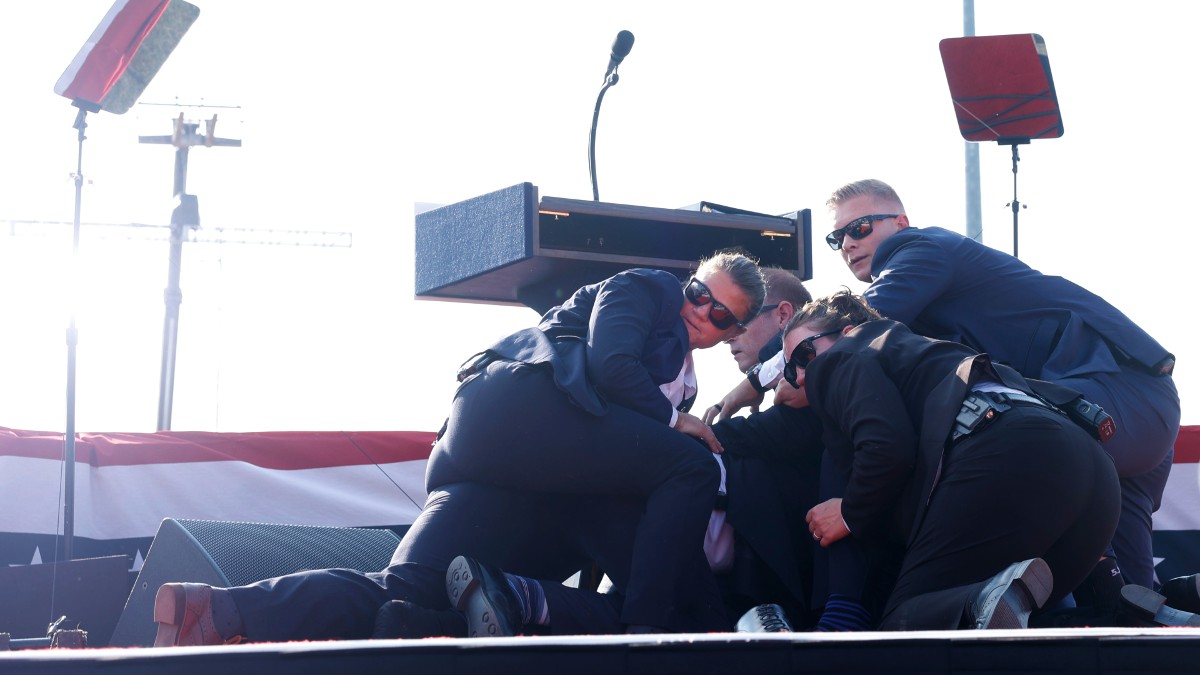 Secret Service agents huddle around Donald Trump