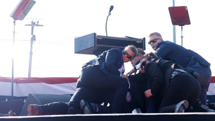 Secret Service agents huddle around Donald Trump