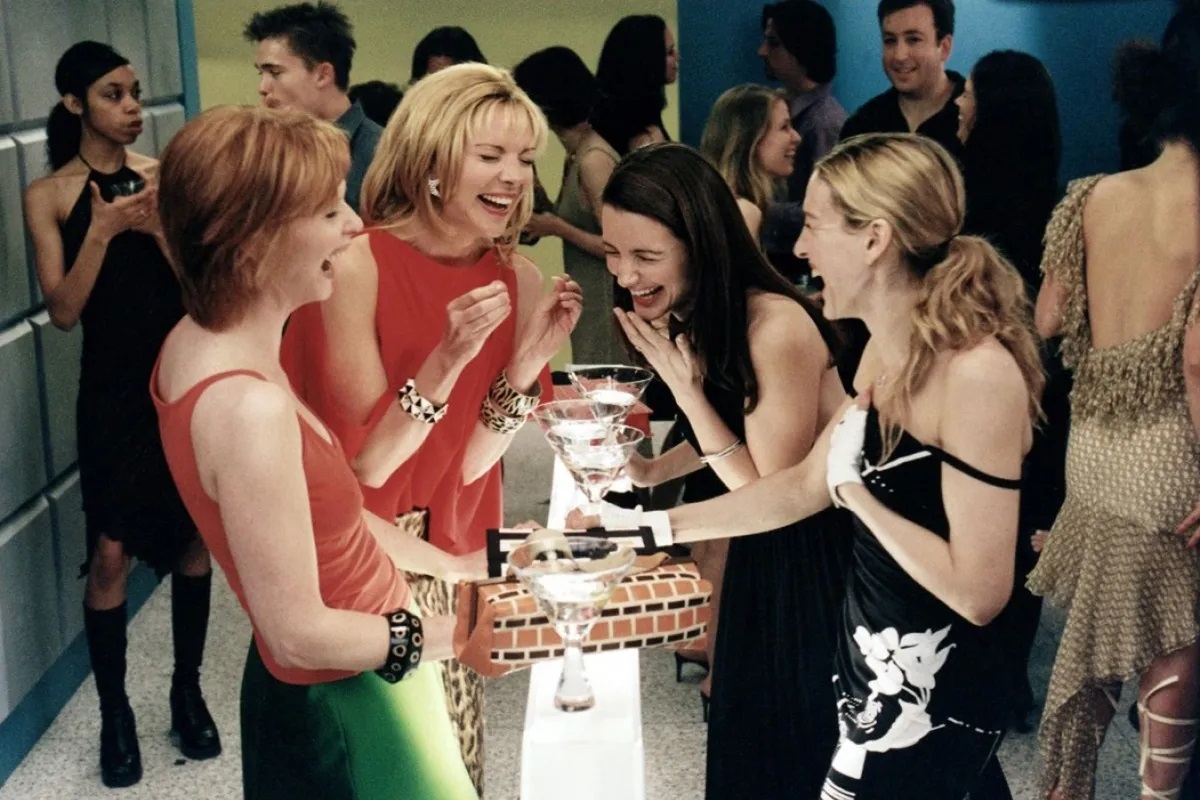 Samantha, Miranda, Carrie and Charlotte laughing in a bar in Sex and the City