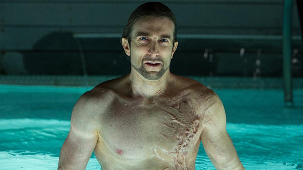 Sharlto Copley as The Stranger in Oldboy, topless and scarred in a bath