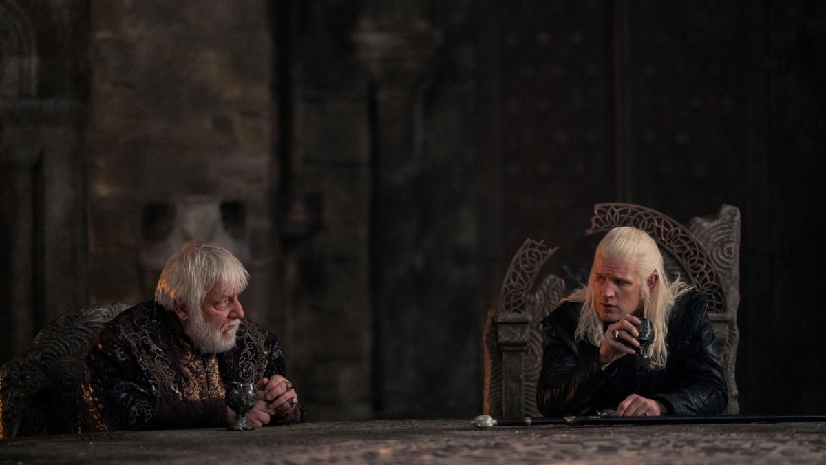Sir Simon Russell Beale as Ser Simon Strong and Matt Smith as Daemon Targaryen sit and drink wine at the table in Harrenhal in House of The Dragon